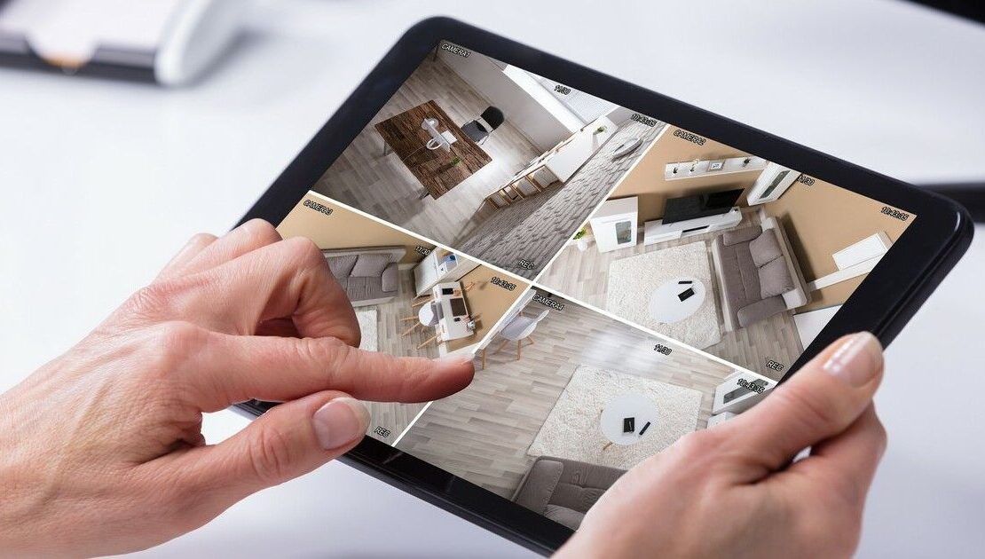 Person Monitoring CCTV Footage On Digital Tablet