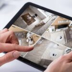 Person Monitoring CCTV Footage On Digital Tablet