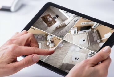 Person Monitoring CCTV Footage On Digital Tablet